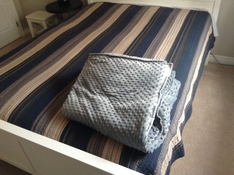 folded weighted blanket on bed